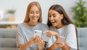 Two friends sharing phone screens.